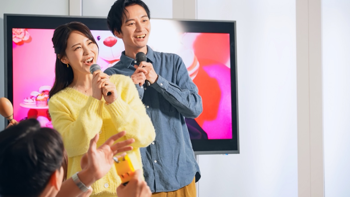 カラオケで歌う若い男女