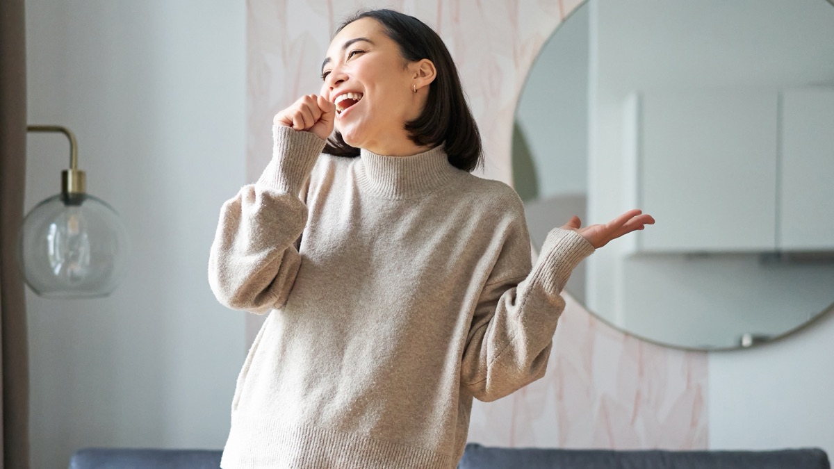 家で楽しそうに歌う若い女性